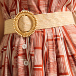 Detail of woven belt and button placket on terracotta print dress.