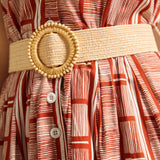 Detail of woven belt and button placket on terracotta print dress.