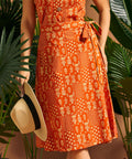 Woman holding hat while wearing a vintage-inspired wrap skirt with pocket.