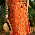 Woman holding hat while wearing a vintage-inspired wrap skirt with pocket.
