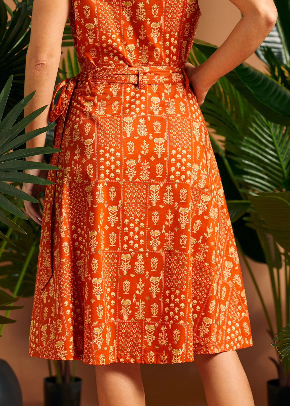 Back view of orange wrap skirt with side tie detail.