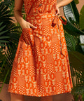 Close-up of functional patch pocket on orange cotton A-line skirt.