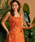 Vintage-style orange cami styled with a straw hat and coordinating skirt.