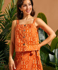Woman wearing a vintage-inspired orange cotton cami with square neckline and front buttons.
