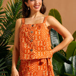 Woman wearing a vintage-inspired orange cotton cami with square neckline and front buttons.