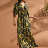 Woman wearing a flowing vintage-inspired jungle print maxi dress with side slit and flutter sleeves.