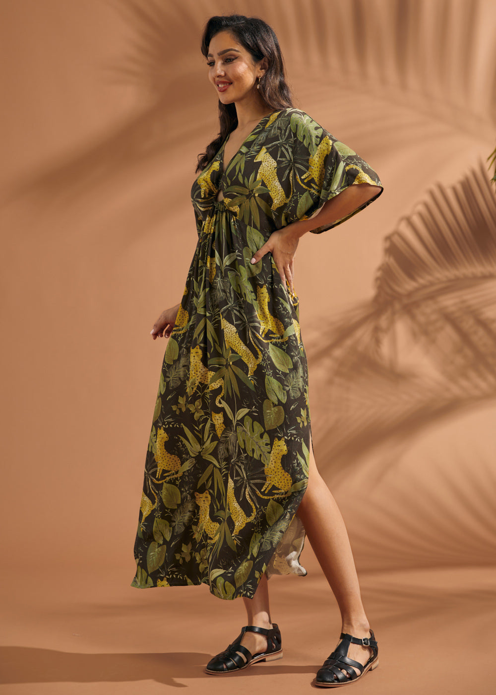 Three-quarter view of a woman wearing a vintage-inspired flutter sleeve maxi dress in a jungle print.