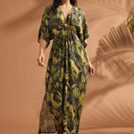 Woman walking in a lightweight jungle print maxi dress with dramatic flutter sleeves and side pockets.