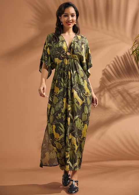 Woman walking in a lightweight jungle print maxi dress with dramatic flutter sleeves and side pockets.