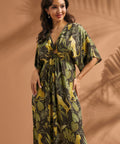 Woman posing in a tropical print maxi dress with front ring detail and flowing silhouette.