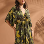Woman wearing a tropical jungle print maxi dress with flutter sleeves and ring front keyhole detail.