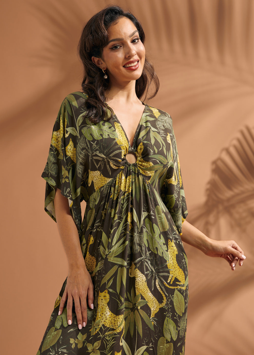 Front view of a woman wearing a relaxed-fit maxi dress with flutter sleeves and novelty jungle print.