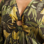 Close-up of the V-neckline with gathered ring detail and keyhole opening on a tropical print maxi dress.