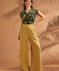 Front view of mustard high waisted pants with pleated wide leg silhouette.