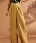 Woman styling wide leg trousers with a printed camp shirt.