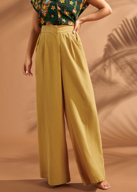Woman styling wide leg trousers with a printed camp shirt.