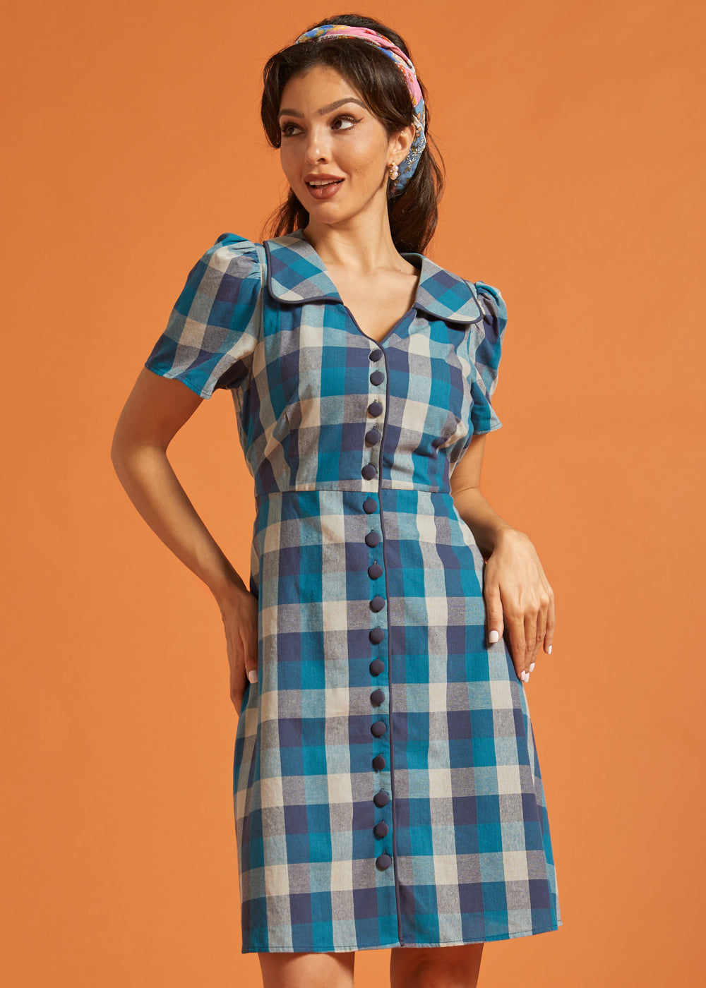 Woman wearing a vintage-inspired blue plaid cotton shirt dress with puff sleeves and oversized collar