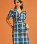 Woman wearing a vintage-inspired blue plaid cotton shirt dress with puff sleeves and oversized collar