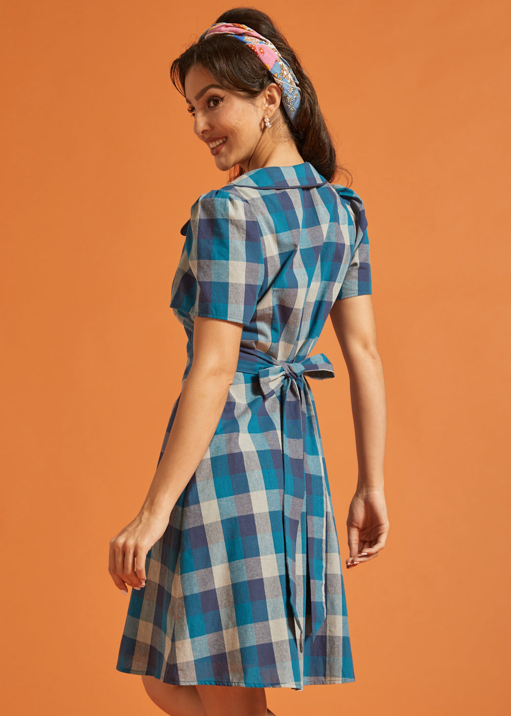 Side view of vintage-inspired blue plaid dress with button-front design and flared skirt