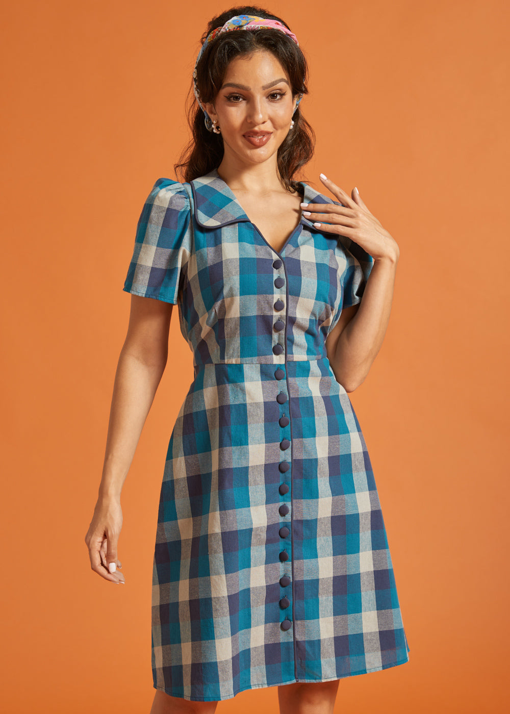 Front view of blue plaid fit-and-flare shirt dress featuring fabric-covered buttons and tie waist