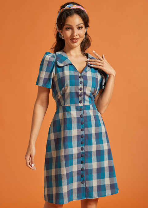 Front view of blue plaid fit-and-flare shirt dress featuring fabric-covered buttons and tie waist