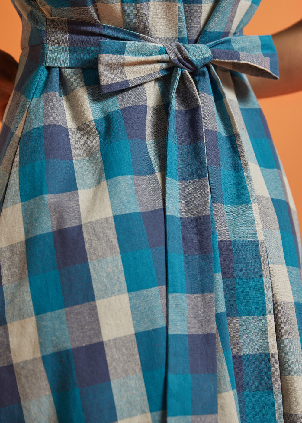 Close-up of back tie belt on blue plaid fit-and-flare dress