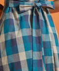 Close-up of back tie belt on blue plaid fit-and-flare dress