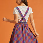 Back view of plaid pinafore dress with crossed straps and elastic waist