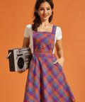 Front view of fit-and-flare plaid jumper dress with pockets