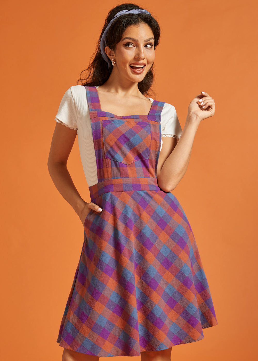 Woman wearing a colorful plaid fit-and-flare jumper dress