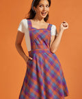 Woman wearing a colorful plaid fit-and-flare jumper dress