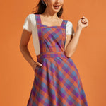 Woman wearing a colorful plaid fit-and-flare jumper dress