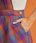 Close-up of plaid fabric, waistband detail, and side pocket
