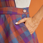 Close-up of plaid fabric, waistband detail, and side pocket