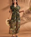 Woman wearing lightweight tropical empire waist maxi dress with side slits and pockets.