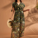 Woman wearing lightweight tropical empire waist maxi dress with side slits and pockets.