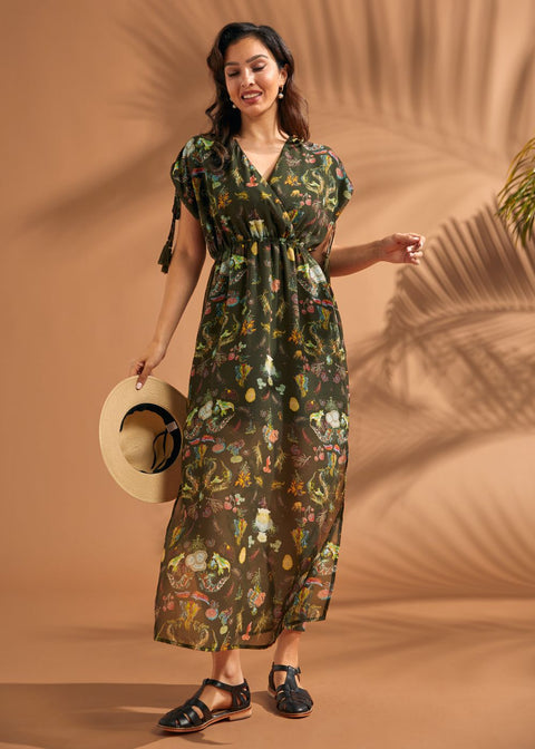 Woman wearing lightweight tropical empire waist maxi dress with side slits and pockets.