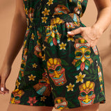 Woman wearing tropical tiki print pull-on shorts with elastic waistband and side pockets.