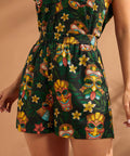 Woman wearing colorful tiki mask print shorts with easy pull-on styling.
