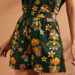 Woman wearing colorful tiki mask print shorts with easy pull-on styling.