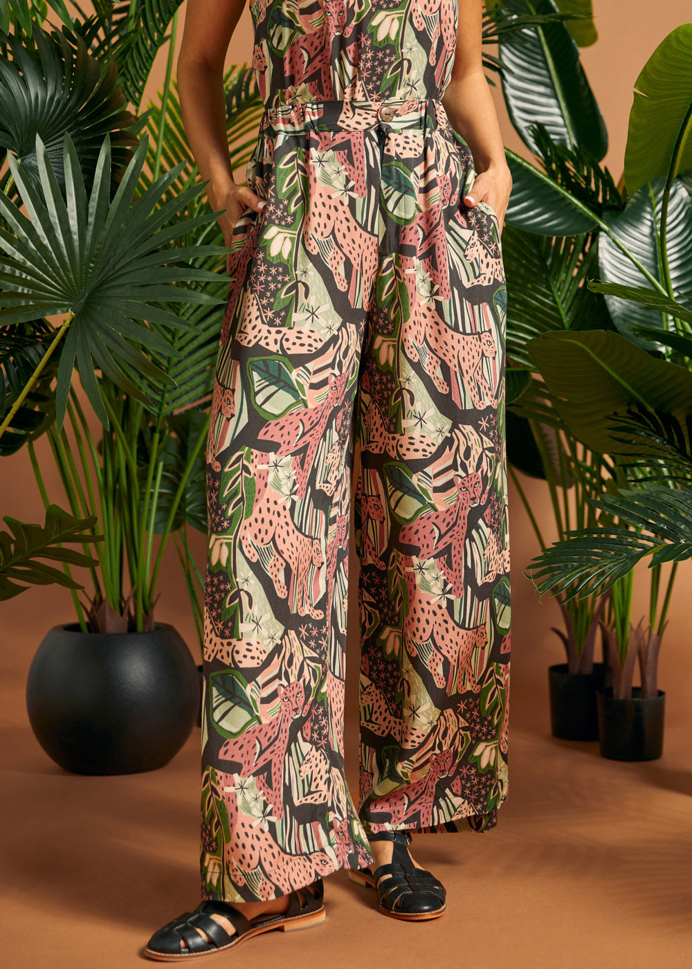 Woman standing with hands in pockets wearing printed palazzo pants.