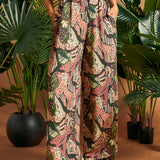 Woman standing with hands in pockets wearing printed palazzo pants.