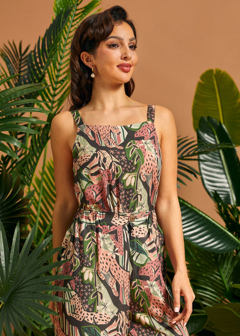 Woman wearing a floral tank top standing among tropical plants with a brown background