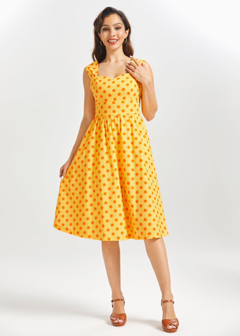 Woman wearing a yellow polka dot dress on a white background
