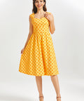 Woman wearing a yellow polka dot dress on a white background