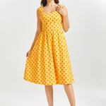 Woman wearing a yellow polka dot dress on a white background