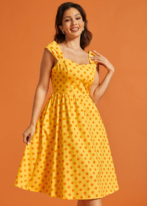 Woman wearing retro-inspired polka dot midi dress with sweetheart bodice and full skirt.