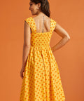Back view of yellow fit and flare dress with stretchy smocked back and gathered skirt.