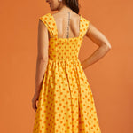 Back view of yellow fit and flare dress with stretchy smocked back and gathered skirt.