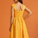Back view of yellow fit and flare dress with stretchy smocked back and gathered skirt.